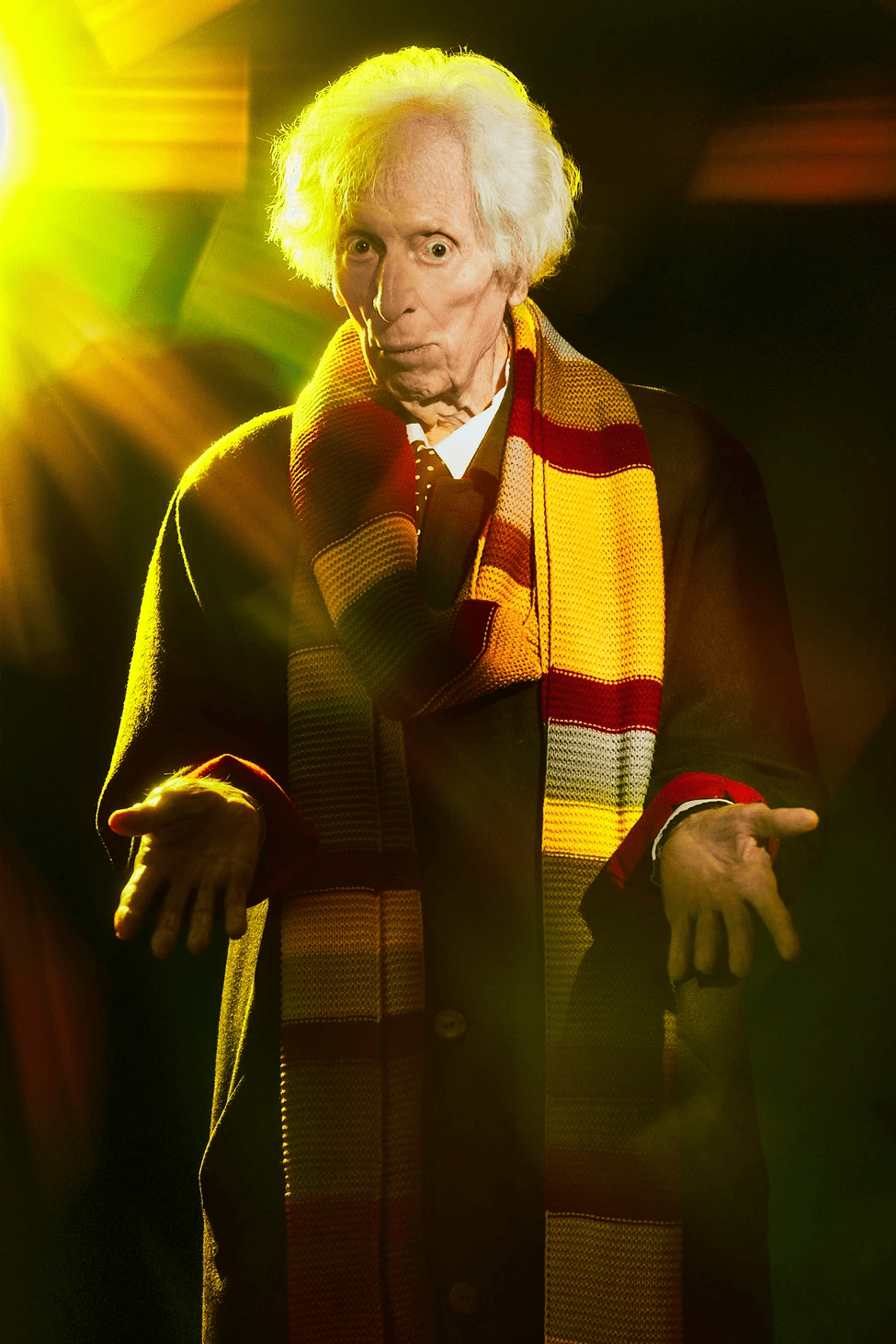 Tom Baker con una réplica de su bufanda del Cuarto Doctor, con las manos extendidas.Tom Baker 